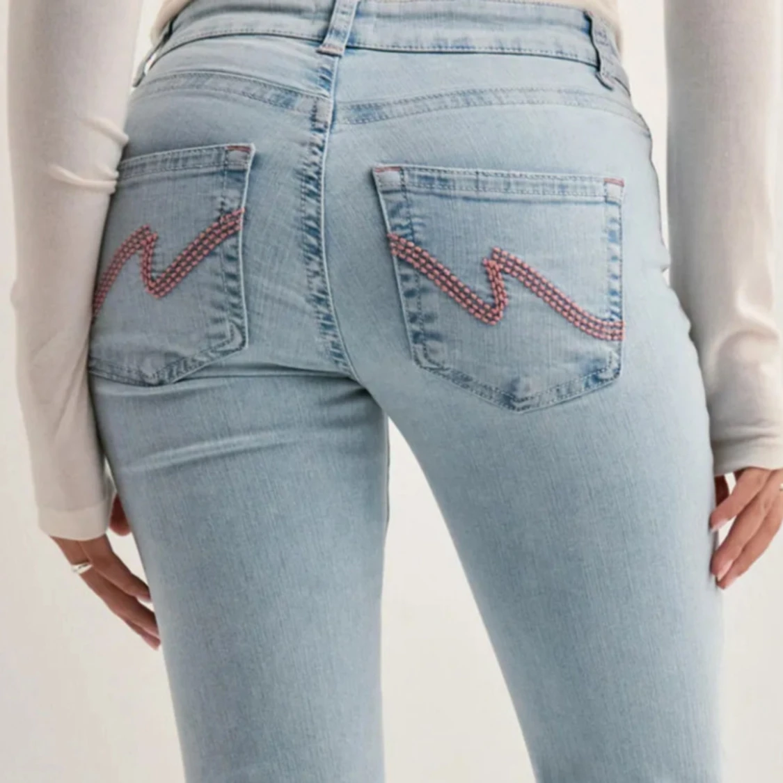 Ljusblå jeans med rosa brodyr från Nelly