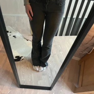 Svarta bootcut jeans från Levis - Snygga svarta jeans från Levis med bootcut-modell och klassisk femficksdesign. Jeansen har en mörk tvätt och sitter tajt upptill med utsvängda ben. Perfekta för dig som gillar en tidlös och clean look.