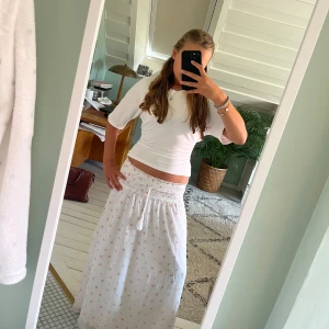 Långkjol från Ginatricot  - En långkjol från Ginatricot med rosa blommor på. Är extremt gullig för sommar, och till fester❤️. Den är i storlek 158/164 och är knappt använd och har då inga skador💕Säljer ganska billigt då sommaren snart är över🫶