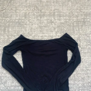 BERSHKA SKIM Svart  långärmad topp  - Svart långärmad topp med snygg offshoulder-design som visar axlarna. Enkel och stilren modell som passar perfekt till jeans eller kjol. Mjuk och stretchig känsla, figurnära passform och klassisk look.