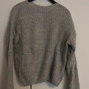 Grå stickad tröja - Säljer en grå stickad tröja. Ärmarna är uppsprättade då dem hade en konstigt vikt längd innan, om det önskas kan jag skicka bild.