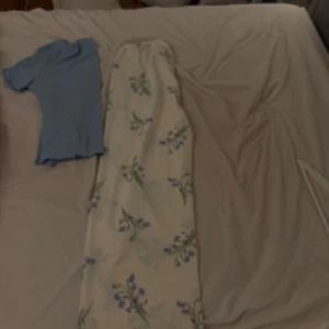 Ljusblå ribbad topp med kort ärm - Supersöt ljusblå topp med ribbad struktur och korta ärmar. Modellen har en lätt utställd midja och en enkel, rund halsringning. Perfekt för dig som gillar en clean och fräsch look med en touch av 90-talsvibe.