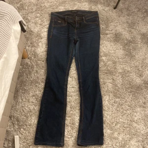 Mörkblå bootcut jeans från Replay - Snygga mörkblå jeans från Replay med klassisk bootcut-passform. Jeansen har fem fickor, kontrastsömmar och läderpatch bak i midjan. Säljer pågrund de blivit för korta, jeansen har inga defekter.