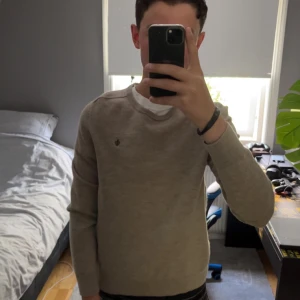 Merinoulltröja från Morris - Säljer en stilren beige tröja från Morris i 100% merinoull. Jag säljer den för att den blivit för liten för mig. Och en Morris logga på bröstet. Perfekt för hösten och snygg till nästan alla outfits. Inga slitningar eller fläkar så skicket är nästan som nytt bara att den är använd men är inget som syns.🔥