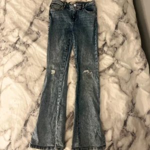 Blå bootcut jeans med slits från ONLY - Snygga blåa bootcut jeans från ONLY i storlek 152. Jeansen har slitna detaljer på benen, klassisk femficksmodell och cool slits nertill vid bensluten. Säljer dåd en är försmå❤️