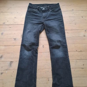 Mörkgrå jeans bootcut - Snygga mörkgrå jeans med klassisk femficksdesign och bootcut-ben. Jeansen har kontrastsömmar och broderade bakfickor. Tillverkade i slitstarkt denim med normal passform och medelhög midja. Mått: midja: 78 cm innerbenslängd: 79 cm gren: 20 cm ytterbensmått: 102 cm