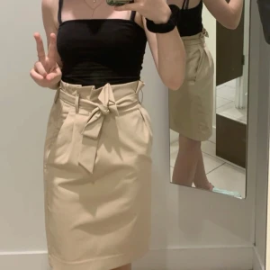 Beige kjol med knytband - Stilren beige kjol med knytband i midjan. Knälång och rak i modellen. ❤️‍🔥Använd fåtal gånger, jättefint skick. Rökfritt hem! Skriv meddelande vid frågor/fler bilder 🩷