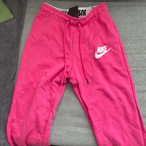Rosa Nike mjukis  - Ett par rosa Nike mjukisbyxor i storlek xs. För små för mig, kommer inte till någon användning.