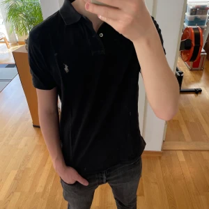 Ralph Lauren piké  - Säljer en sjukt fet Svart Ralph Lauren piké i strl M. Den är i mycket bra skick o hör gärna av er vid frågor eller funderingar!!