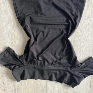 Svart topp  - Snygg svart topp i en elegant design. Perfekt för olika tillfällen med sin stilrena look. Toppen har en figurnära passform och är tillverkad i ett mjukt material. Man kan också vika ned övre delen så att det blir of shoulder 🩷🩷