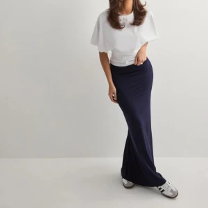 Mörkblå långkjol - Snygg mörkblå långkjol med en tight passform. Perfekt för en stilren look. Kjolen är enkel och elegant, vilket gör den lätt att matcha med olika toppar och skor. Passar S och Xs