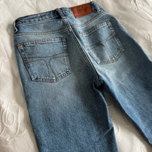 Blå jeans från Tiger of Sweden - Snygga blå jeans från Tiger of Sweden med klassisk femficksdesign och dragkedja. Perfekta för en stilren look. Tillverkade i högkvalitativt denim.
