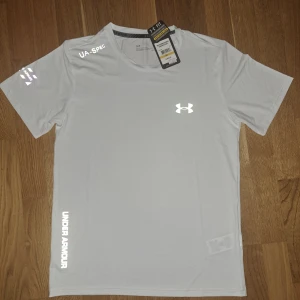 Under Armour tröja - Snygg vit t-shirt från Under Armour. Aldrig använts förr skicket är 10/10