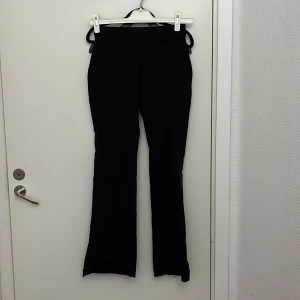 Svarta kostymbyxor från BikBok - Snygga svarta kostymbyxor från BikBok i storlek 34. Byxorna har en klassisk design med bälteshällor och en elegant passform. Perfekta för en stilren look.