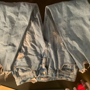 Ljusa jeans från Pull&Bear - Säljer ett par ljusa jeans från Pull&Bear. De har en avslappnad stil med slitna detaljer och fransar vid kanterna. Perfekta för en casual look. 👖✨