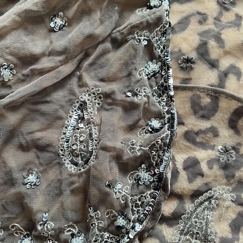 Säljer en elegant svart bolerotopp från Indiska. Den är dekorerad med glittriga paljetter och har ett vackert broderat mönster. Perfekt för att lägga till lite glamour till din outfit.. Neuletakit & Villapaidat.