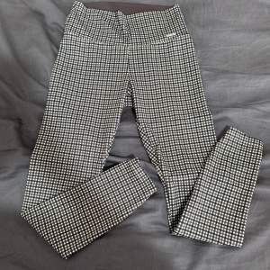 Snygga rutiga tights i svart och vitt med hög midja. Tillverkade i en mjuk och stretchig blandning av polyester och spandex för en bekväm passform. Perfekta för en stilren look.