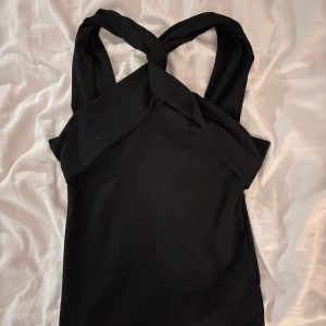 Svart topp från Gina Tricot - Snygg svart topp från Gina Tricot med korsade band framtill. Perfekt till sommaren och fest! Storlek XS, hör av dig vid intresse!🩷Aldrig använd!