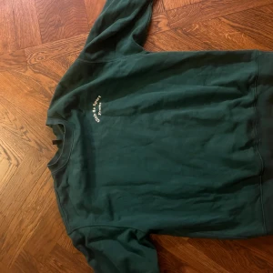 Grön sweatshirt från H&M Divided - Säljer en grön sweatshirt från H&M Divided. Tröjan har en enkel design med rund hals och långa ärmar. Perfekt för en avslappnad stil.