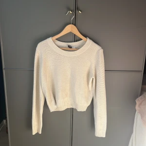Vit stickad tröja - Säljer en stilren vit/beige stickad tröja med rund hals och långa ärmar. Perfekt för kyligare dagar och enkel att matcha med olika outfits. Tröjan har en ribbad kant vid ärmslut och nederkant för en snygg passform.💕💕