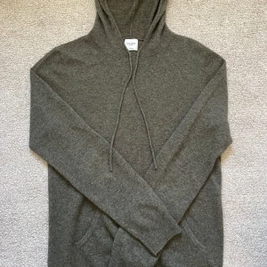John Henric Kashmir hoodie  - Mörkgrön hoodie från John Henric i kashmir. Tröjan har huva med snörning, magficka och långa ärmar. Perfekt för dig som gillar en clean och stilren look med extra komfort. Köpt för mindre än en vecka sen för 2499kr. Priset är it hugget i sten.