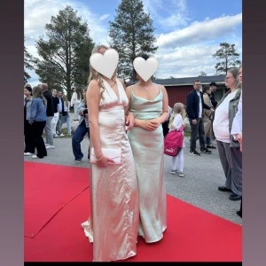 Champagnefärgad balklänning - Säljer min champagnefärgade balklänning från IVORYFIELD, den är endast använd 1 gång. Köptes ny från hemsidan för 3000kr och säljer nu för 1700kr🥰 Klänningen kan man knyta på många olika sätt, exempel på de 2 sista bilderna. Säljer även den superfina väskan ni ser på bilderna i annat inlägg🥰🤩