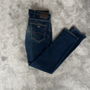 Mörkblå jeans från Emporio Armani - Snygga mörkblå jeans från Emporio Armani med klassisk femficksdesign och tydliga kontrastsömmar⭐️ Byxorna har slim/straight passform, med den klassiska metall loggan på bakfickan. Perfekta för dig som gillar stilrena och tidlösa jeans. Hör gärna av dig vid frågor 🤩