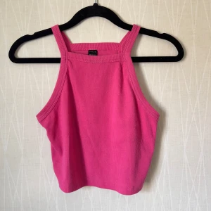 Rosa ribbad linnetopp från SHEIN - Säljer en snygg rosa ribbad linnetopp från SHEIN i storlek M. Toppen har raka axelband och är croppad, perfekt till jeans eller kjol. Materialet är stretchigt och bekvämt, och färgen är riktigt poppig för dig som vill sticka ut.