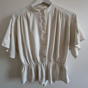 Vit blus från H&M - Säljer en stilren superfin blus från HM med en volang kant längst ner 🌸