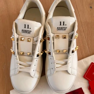Valentino Rockstud vita sneakers - Snygga vita Valentino Rockstud sneakers med guld nitar. Aldrig använda då dom var för små.