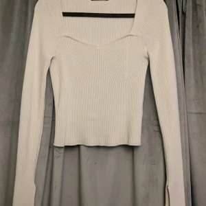 Ljusbeige ribbad tröja Gina Tricot - Supersnygg ljusbeige ribbad tröja från Gina Tricot med lång ärm och fyrkantig ringning. Tröjan är figurnära och har slits vid ärmsluten för en extra detalj. Mycket bra skick och jätte skön!🫶🏻