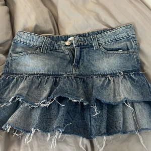 Volangkjol i jeans från Gina Tricot - Säljer en blå jeanskjol från Gina. För att den inte kommint till användning. Som ny i skick. Passar mig som är 160cm. Hör av dig vid frågor ❤️