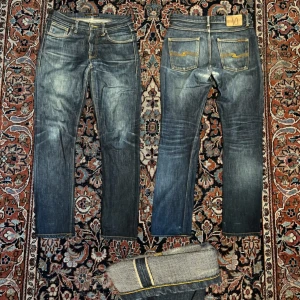 Selvage nudie jeans - Sjukt feta selvage nudie jeans! Selvage innebär att de är mycket bättre material än andra jeans. De skapar en tvätt under tiden man använder de. Dessa har redan fått en skön tvätt men om man använder dem mer kommer de få en ännu bättre. Midja:42cm längd:100cm