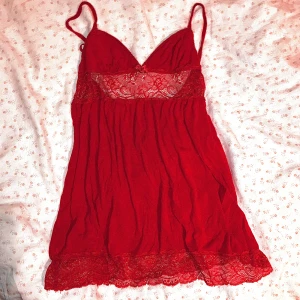 Röd spetslinnetopp i XS - Supersöt röd linnetopp från H&M med tunna axelband och vacker spetsdetalj över bysten och nederkanten. Toppen har en liten rosett framtill och är gjord i mjukt, lätt material som faller snyggt. Perfekt för dig som gillar romantiska vibes.