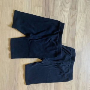 Svarta cykelshorts i bomull - Två par svarta cykelshorts i stretchig bomull med elastisk midja. Perfekta för träning eller chill, klassisk modell utan detaljer. Säljes i storlek 140 och 146. Säljes 25kr styck eller 40kr tillsammans 
