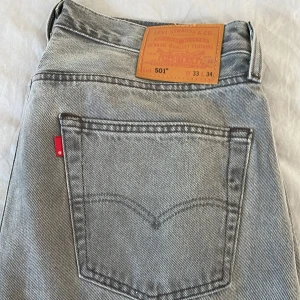 Levi's 501 grå jeans straight fit - Säljer ett par klassiska Levi's 501 jeans i snygg grå tvätt. Jeansen har rak passform, fem fickor och den ikoniska röda Levi's-taggen bak. Tillverkade i slitstarkt jeanstyg och passar perfekt till en avslappnad streetstil. Dessutom helt oanvända testade på en gång. Inte använda en ända gång! Tyvärr ingen prislapp men utöver de oanvända.