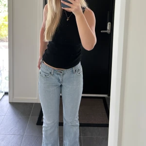 Ljusblå bootcut jeans från Signature - Säljer ett par ljusblå jeans från Signature med låg midja och bootcut-ben. Jeansen har klassisk femficksdesign, snygga kontrastsömmar och är tillverkade i bomull med lite stretch för skön passform.