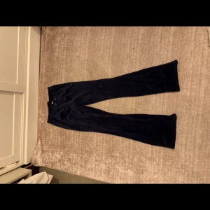 Mörkblå sammetsbyxor med bootcut - Snygga mörkblå byxor i mjuk sammet med bootcut-silhuett. Byxorna har resår i midjan och snörning framtill för extra komfort. Perfekta för dig som vill ha en chill men ändå trendig look.