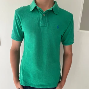  Polo Ralph Lauren piké - Säljer en grön polo Ralph lauren piké! Pikén är i bra och sparsamt skick. Killen på bilden är c.a 170cm och tröjan sitter tajt och litet! Tveka inte på att höra av er vid minsta fundering. Bundle är möjligt!