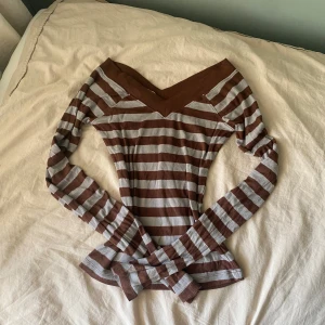 V-neck downtown girl tröja - Superfin långärmad topp från BDG i brunt och grått med breda ränder. Tröjan har en snygg v-ringad offshoulder-skärning och är ribbad i materialet. 