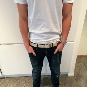 Beige flätat bälte från Tressé  - Snyggt beige flätat bälte från Tressé (mitt UF) med detaljer i brunt skinn och silverspänne. Bältet har en stilren och modern look som passar perfekt till jeans eller chinos. Flätad design ger en cool och avslappnad känsla. Har 13 stycken kvar, så skynda innan de tar helt slut. 
