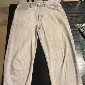 Grå loose fit jeans från H&M - Säljer ett par gråa loose fit jeans från H&M i storlek 30/32. Byxorna har klassisk femficksdesign, raka ben och är tillverkade i ett mjukt jeanstyg. Perfekta för en avslappnad och trendig stil.