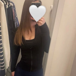 Jättefin svart träningskofta från Gina Tricot!! - Jättefin och skön svart träningskofta från Gina Tricot med dragkedja framtill. Långärmad och i mjukt material som sitter tajt och markerar figuren. Perfekt för dig som gillar en clean och enkel look!! Använd några gånger men inga hål eller lösa trådar finns! Den kostade 359kr i butik❤️Köparen står alltid för frakten