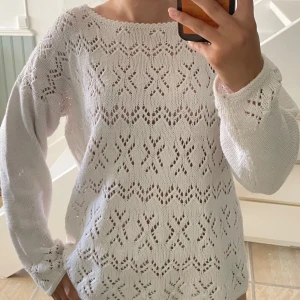 Vit stickad tröja - Superfin vit stickad tröja med snyggt hålmönster och boatneck. Perfekt som beach coverup eller vanlig stickad tröja. Skönt material 