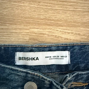 Blå wide jeans från Bershka - Snygga blå jeans från Bershka i storlek 36 med breda ben och cool tvättad look. Klassisk femficksmodell med hög midja och raka, vida ben. Perfekta för en avslappnad och trendig stil.