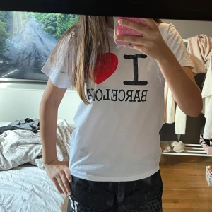Vit I ❤️ Barcelona t-shirt - Vit t-shirt med trycket 'I ❤️ Barcelona' köpt i Barcelona! Jättenajs att ha! Står stolek 12-14 på lappen men det ska vara storlek S och köpte den i storlek S! Passar dessutom mig med storleken S❤️Aldrig använt 