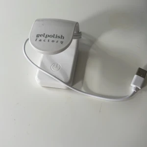 Gelpolish Factory UV-lampa för naglar - Vit UV-lampa från Gelpolish Factory med USB-sladd, perfekt för att härda gelnagellack hemma. Kompakt design med enkel touch-knapp för att starta lampan. Smidig att ta med och använda för snygga naglar när som helst.🌸
