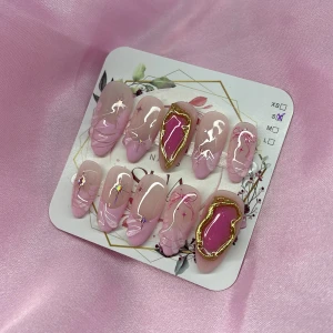 SakuraGem (S);Medium Almond - Snygga gelé press-on naglar i rosa handmålad french och nude med trndiga-mönster, stjärndekor och två naglar med metallic guld 3D nailart och stark rosa detalj. Perfekt för dig som vill ha unika och trendiga naglar utan salong. I storlek S: 15 mm, 11,5 mm, 12 mm, 11 mm, 9 mm 