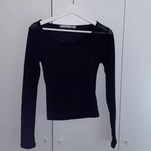 tajt svart långärmad topp - säljer en svart ribbad långärmad topp med spetsdetalj i urringningen!! säljer då den inte kommer till användning