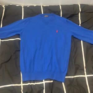 Blå v-ringad tröja Polo Ralph Lauren - Blå v-ringad tröja från Polo Ralph lauren. Funkar bra med en skjorta under och har en bra passform. Säljs pga storleken 